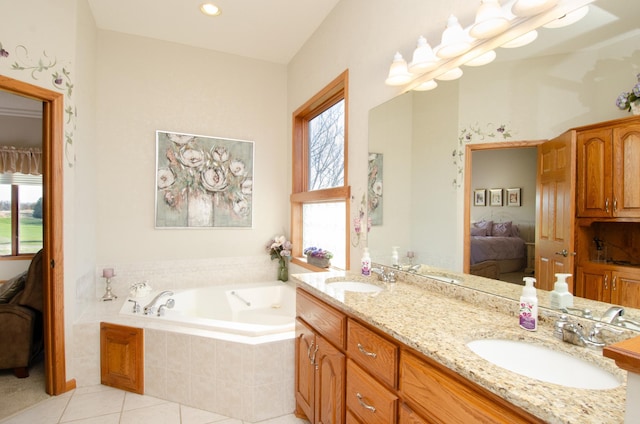 bathroom featuring vanity, tile patterned flooring, tiled tub, and plenty of natural light