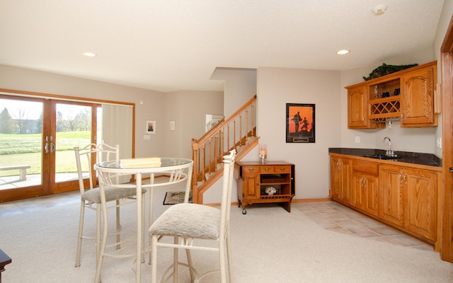 dining space featuring french doors, wet bar, and light colored carpet