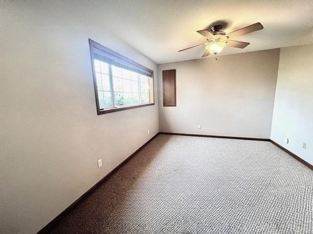 empty room featuring ceiling fan, baseboards, and carpet flooring