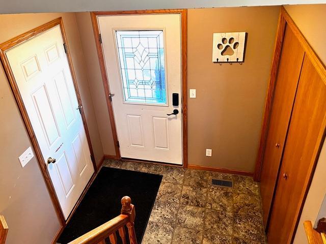 doorway to outside featuring visible vents and baseboards