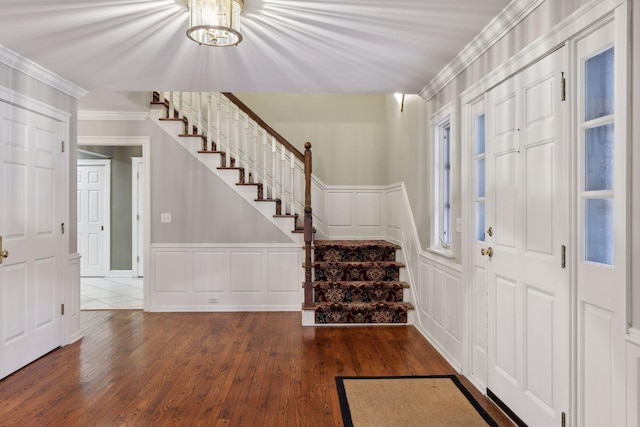 foyer entrance with dark wood-type flooring and ornamental molding