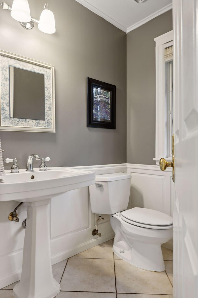 bathroom featuring tile patterned floors, toilet, and ornamental molding