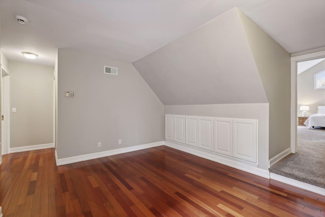 additional living space with dark hardwood / wood-style flooring and lofted ceiling