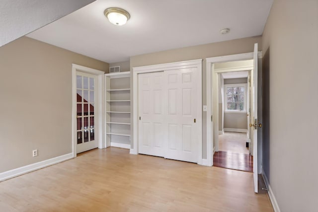 unfurnished bedroom featuring a closet and light hardwood / wood-style flooring