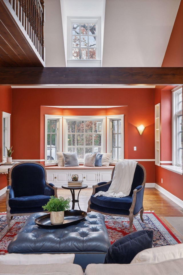 living room featuring plenty of natural light, light hardwood / wood-style floors, and a high ceiling