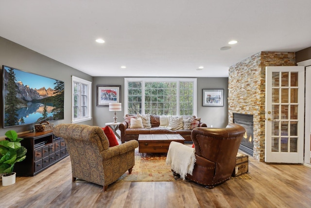 living room with a fireplace and light wood-type flooring