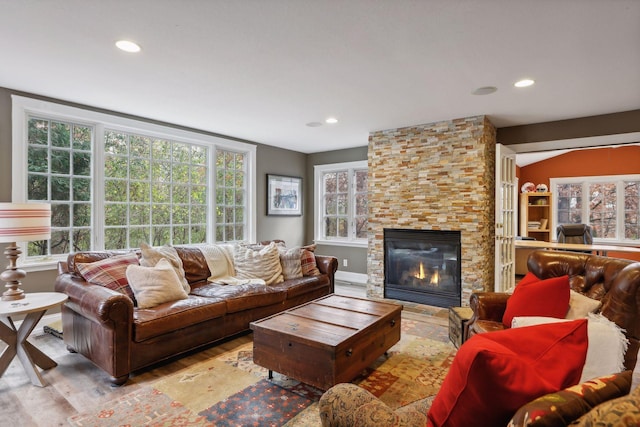 living room with a wealth of natural light, light hardwood / wood-style floors, and a fireplace