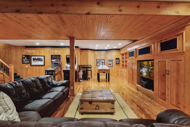 living room featuring light wood-type flooring, wood walls, beam ceiling, and wood ceiling