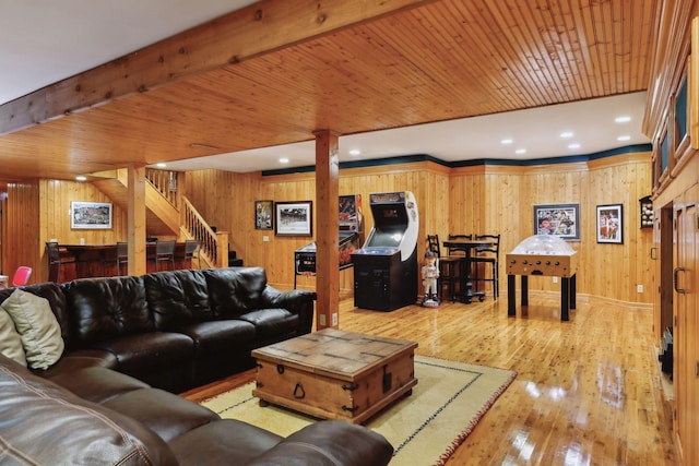 living room with beamed ceiling, wooden walls, hardwood / wood-style floors, and wood ceiling