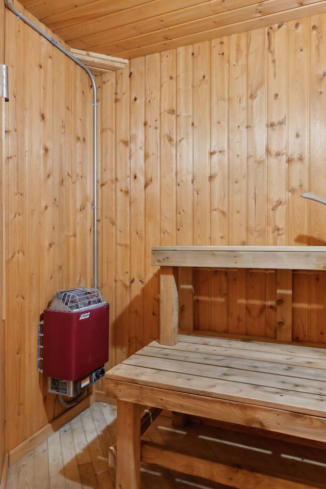 view of sauna with hardwood / wood-style floors, wood walls, and wooden ceiling