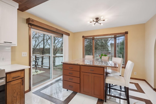 tiled dining space featuring plenty of natural light and a notable chandelier