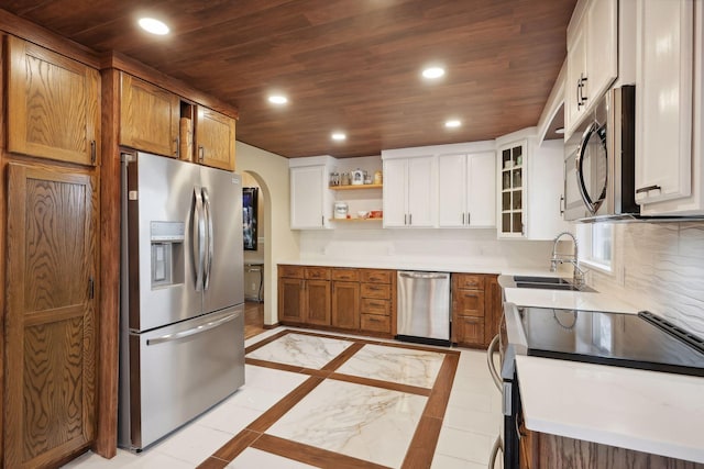 kitchen with wooden ceiling, light tile patterned floors, white cabinets, sink, and stainless steel appliances