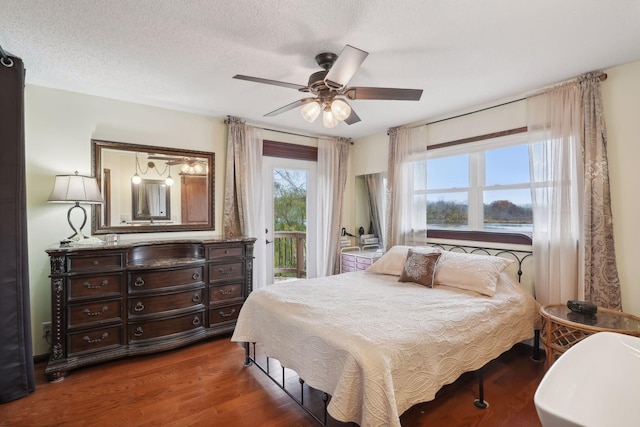 bedroom featuring ceiling fan, a textured ceiling, dark hardwood / wood-style flooring, and access to outside