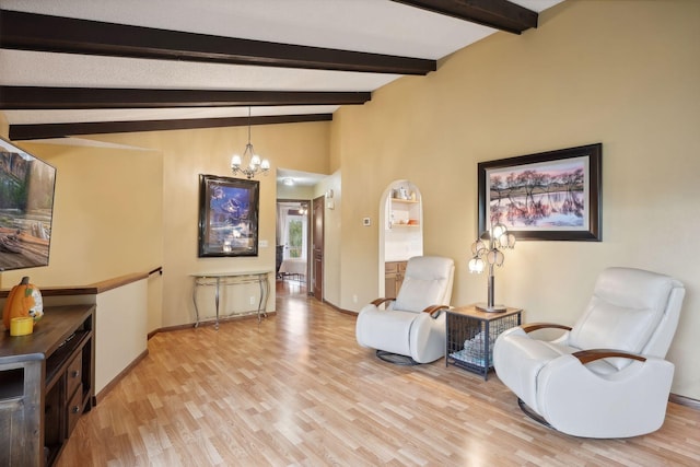 living area with light hardwood / wood-style floors, lofted ceiling with beams, and a chandelier