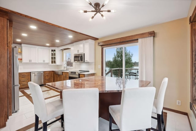 tiled dining room with sink and a notable chandelier