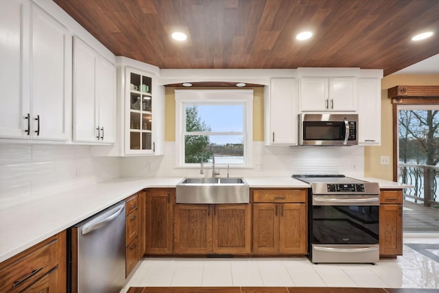 kitchen featuring wooden ceiling, sink, white cabinetry, and stainless steel appliances