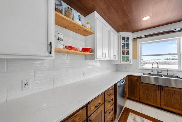 kitchen featuring wooden ceiling, light tile patterned floors, stainless steel dishwasher, sink, and white cabinets