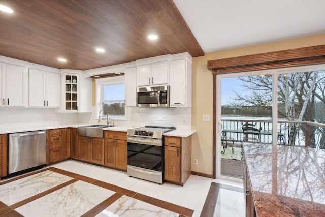 kitchen featuring sink, backsplash, white cabinetry, and appliances with stainless steel finishes