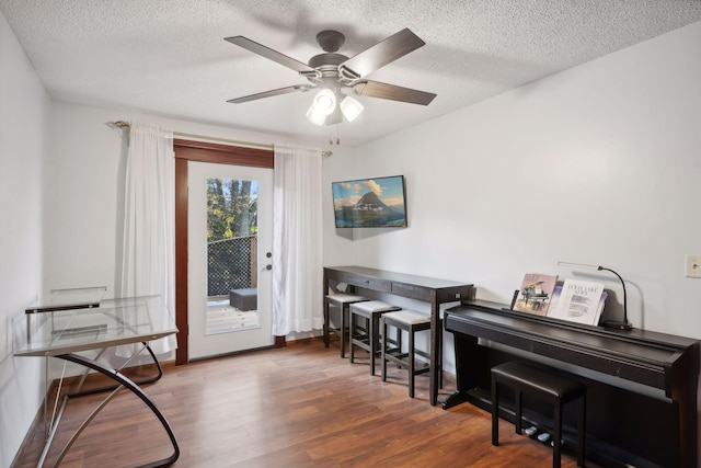 interior space featuring dark wood-type flooring, a textured ceiling, and ceiling fan