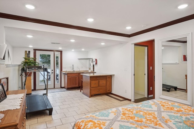 kitchen featuring light stone counters, ornamental molding, and light tile patterned floors