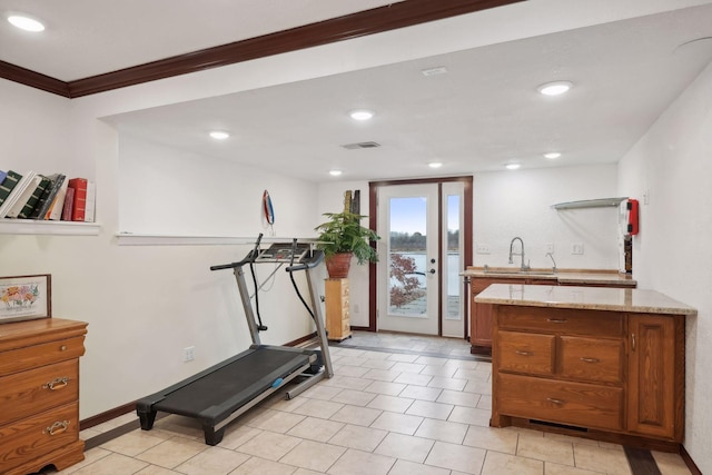 exercise area with sink, ornamental molding, and light tile patterned floors