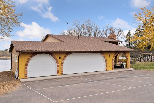 view of side of home with a garage and a water view