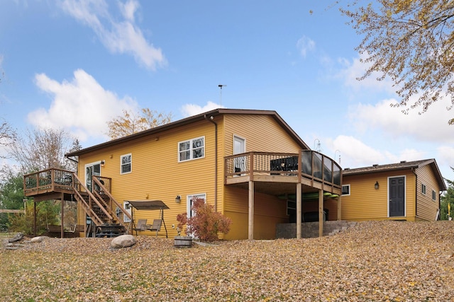 back of house with a wooden deck and a sunroom