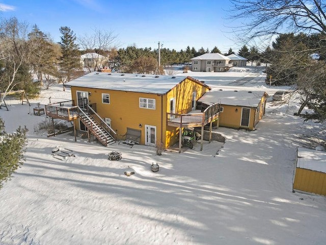 snow covered house featuring a deck