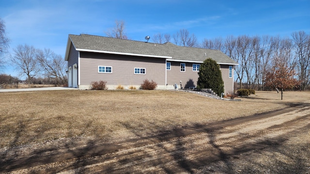 rear view of house featuring a lawn and a garage