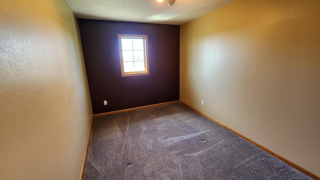 spare room with a textured ceiling and carpet