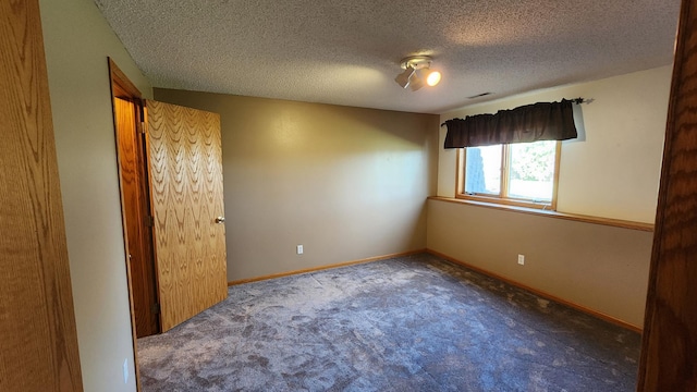 unfurnished bedroom with a textured ceiling and carpet flooring