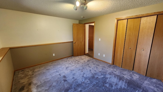 unfurnished bedroom featuring light carpet, a textured ceiling, and a closet