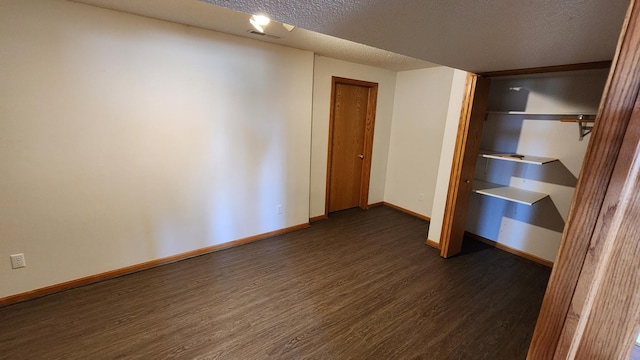 interior space with a textured ceiling and dark hardwood / wood-style floors