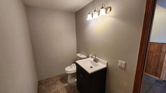 bathroom featuring vanity, toilet, and a textured ceiling