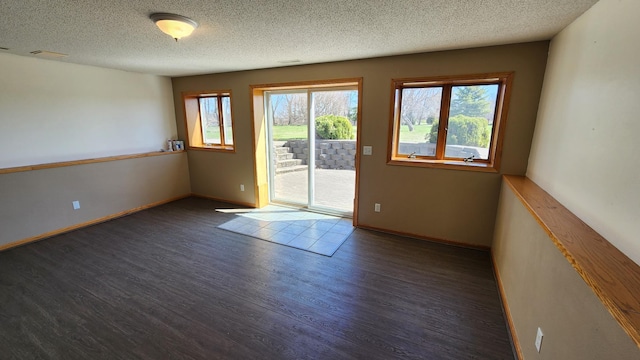 empty room featuring a textured ceiling and dark hardwood / wood-style floors