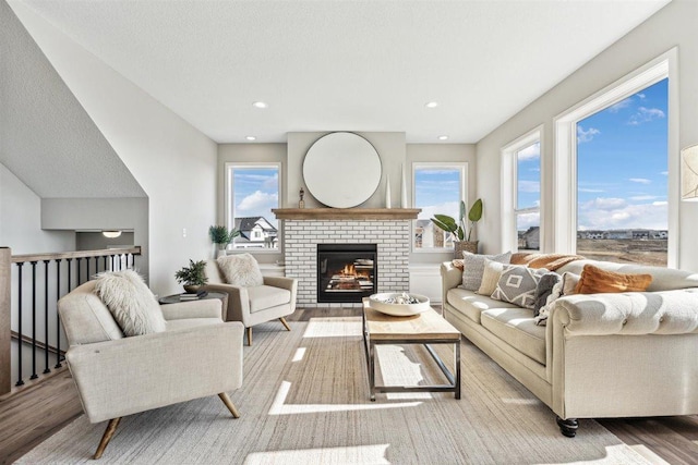 living room with a fireplace and light wood-type flooring