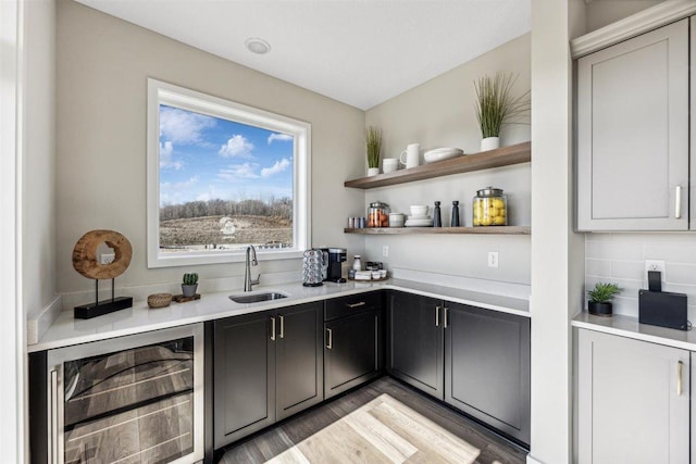 bar featuring decorative backsplash, hardwood / wood-style flooring, wine cooler, and sink