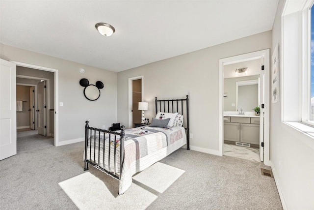 carpeted bedroom with ensuite bathroom and sink