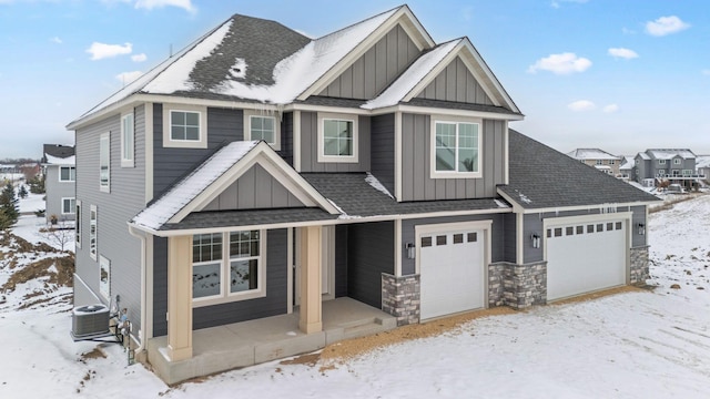 view of front of property featuring a garage and central AC