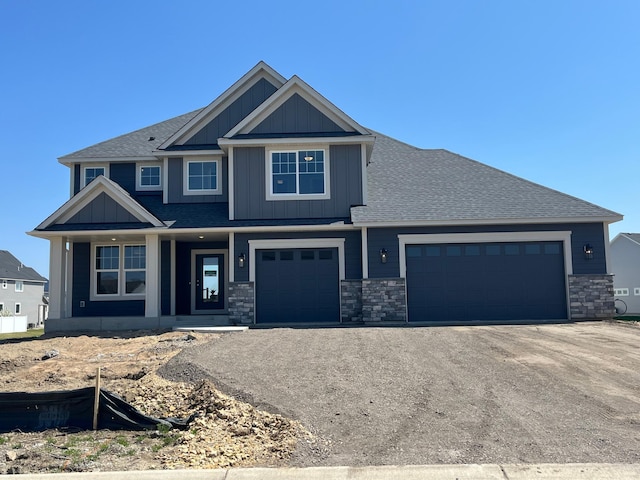 15701 Aquila Ave, Savage, MN 55378 - view of front facade featuring board and batten siding, a shingled roof, a porch, and driveway