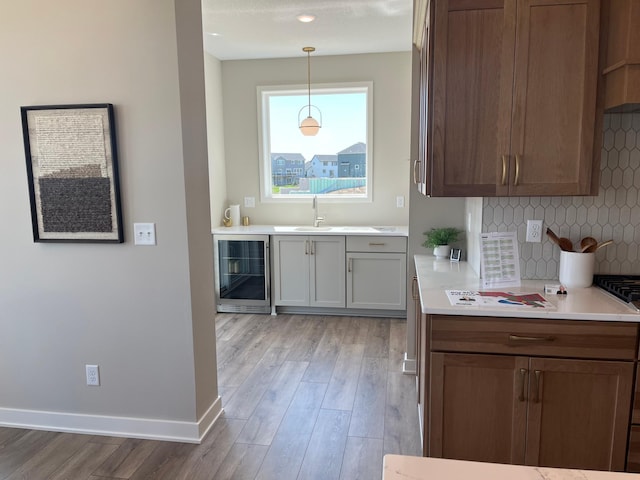 15701 Aquila Ave, Savage, MN 55378 - kitchen featuring a sink, decorative backsplash, light wood-style flooring, and wine cooler