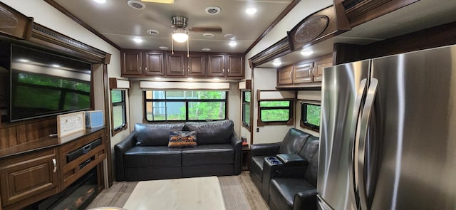 kitchen featuring lofted ceiling, stainless steel fridge, dark brown cabinets, ceiling fan, and crown molding