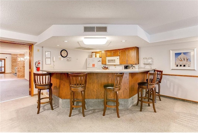 bar with light carpet, a textured ceiling, and white appliances