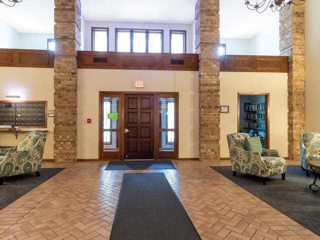 interior space featuring a towering ceiling, decorative columns, and a wealth of natural light