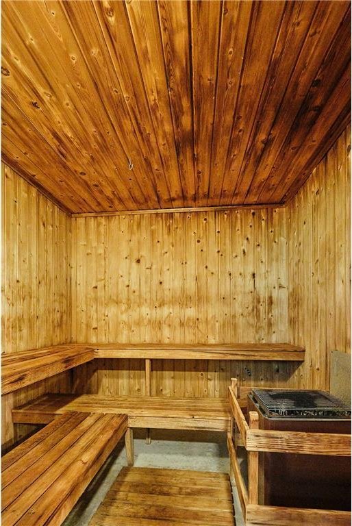 view of sauna with hardwood / wood-style flooring, wooden ceiling, and wooden walls