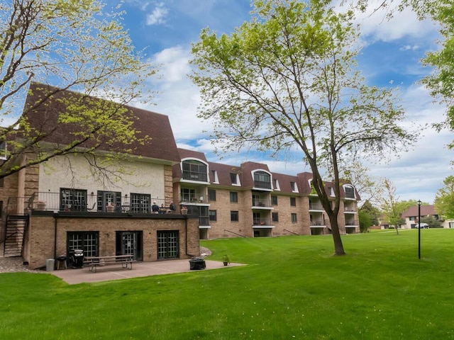 view of property's community featuring a patio area and a lawn