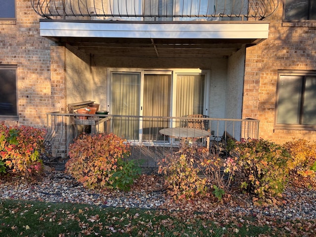 view of exterior entry featuring a balcony