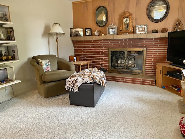 living room featuring wood walls, carpet floors, and a fireplace