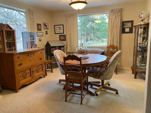 dining room featuring light carpet and plenty of natural light