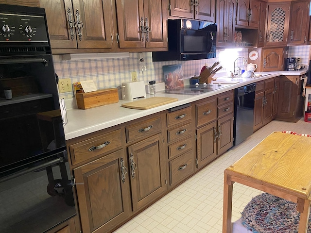 kitchen with tasteful backsplash, black appliances, and sink